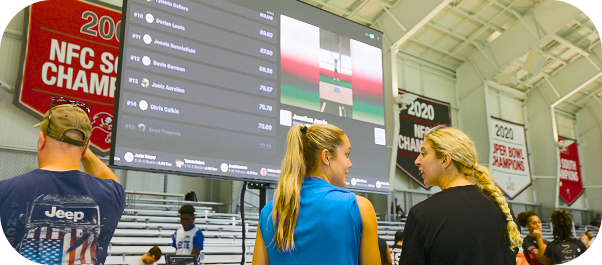 Athletes at combine event with digital leaderboard